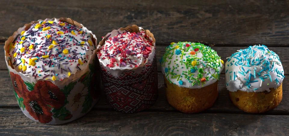 4 Easter cakes with different toppings and different sizes. On wood texture.  Stock Photos