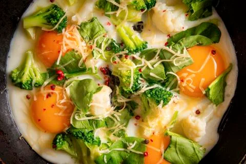 4 fried eggs with broccoli, spinach, spices and cheese in a pan , Breakfast,  Stock Photos