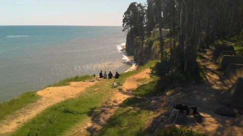 4 friends setting at the top of the cliff near the ocean Stock Footage 88887428