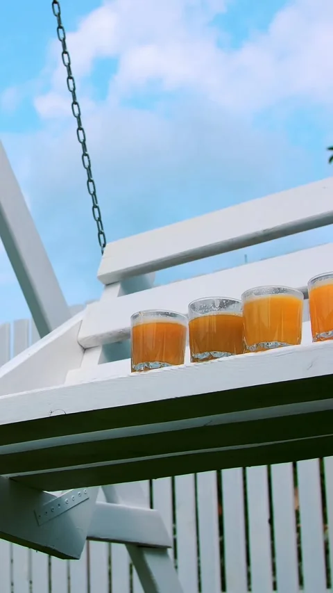 4 glasses with freshly squeezed orange and peach juices are standing, decorated Stock Footage 316888769