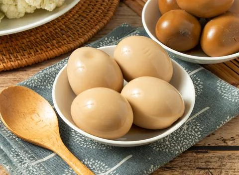 4 Golden chicken Egg in a white bowl with wood spoon isolated on mat top view Stock Photos