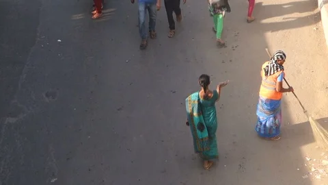 4-High-Angle-View-woman-sweeping-street-busy-bus-stop-people-traffic Stock Footage 89420304