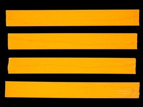 4 horizontal pieces of orange masking tape isolated on a black Stock Photos
