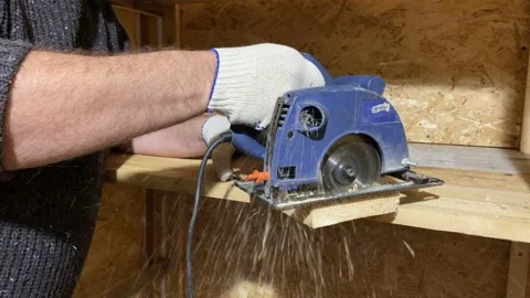 4 k electric circular saw of a man saws a wooden block. Construction concept Stock Footage 221104257