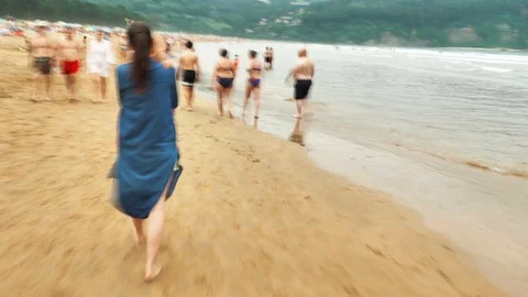 4 k hyperlaps mother with her small child walking among the beach with people Stock Footage 93285805