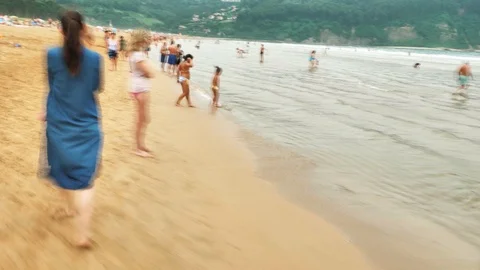 4 k hyperlaps mother with her small child walking among the beach with people Stock Footage 93285827