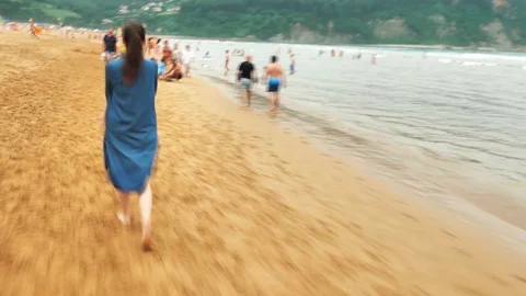 4 k hyperlaps mother with her small child walking among the beach with people Stock Footage 93285853