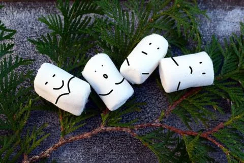 4 marshmallows lie with painted faces. Stock Photos