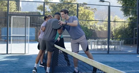 4 men moving to net after match ending, giving padel taps, shakes, hugs, showing Stock-Footage 342067277