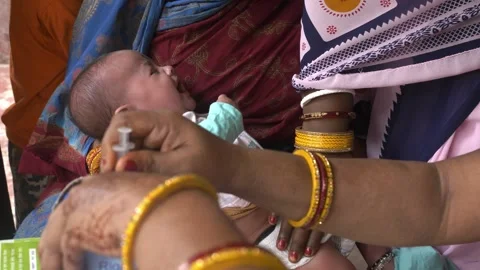 4 months old child crying after polio vaccine in rural Indian town of Norther Stock Footage 295773553