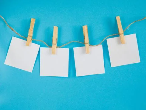 4 Note empty paper cards hanging with wooden clip or clothespin on rope strin Stock Photos