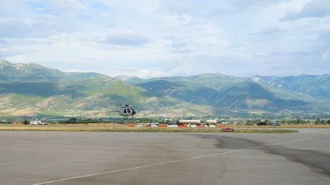 4 seats 1 engine silver colored helicopter is flying forward over ramp 스톡 동영상 116267838