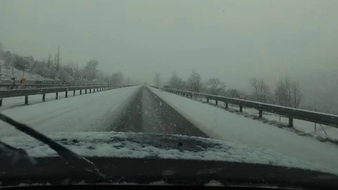 4-wheel car with studded winter tyre runs snow-covered Highway - POV Stock Footage 74699050