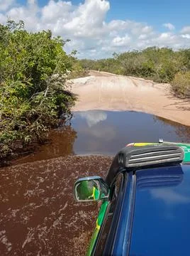 4 x 4 offroad car crossing a dirt road on a tropical forest. rally adventure. Stock Photos
