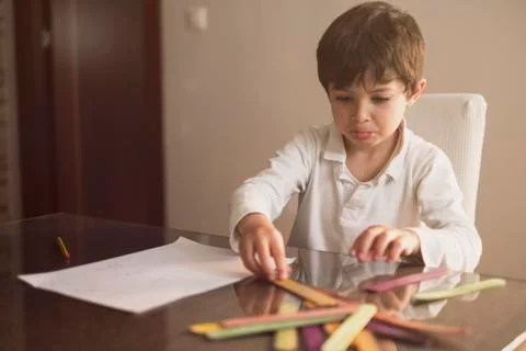 4-year-old boy does homework at home.He Does addition and subtraction operati Stock Photos