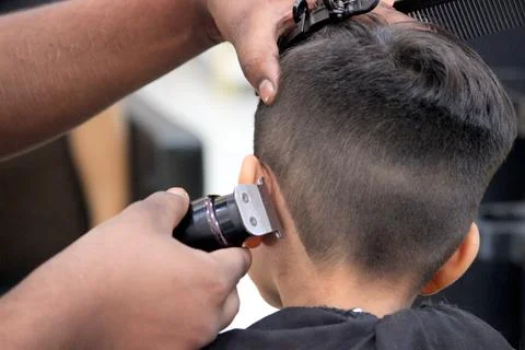 4 year old boy is getting his haircut done at barber shop Foto stock
