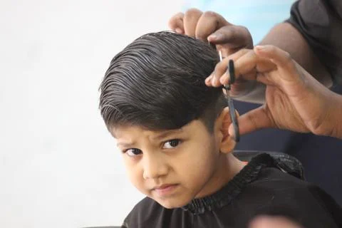 4 year old boy is getting his haircut done at barber shop Foto stock