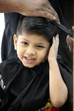 4 year old boy is getting his haircut done at barber shop Foto stock