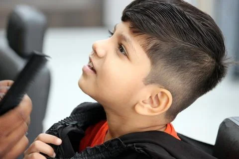 4 year old boy is getting his haircut done at barber shop Foto stock