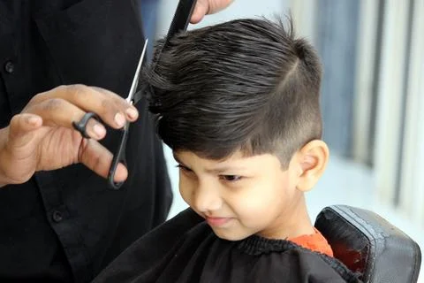 4 year old boy is getting his haircut done at barber shop Foto stock