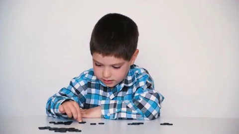 A 4-year-old boy is learning to count, teaching black numeracy chips for Video stock 194474100