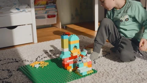 4 year old boy playing lego in the children's room on a sunny day Stock Footage 301866030