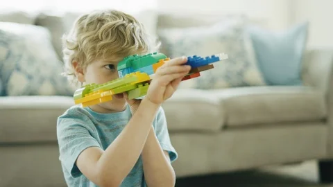 4 year old boy plays with building block spaceship pretending to fire missiles Video stock 127545779