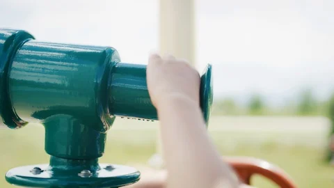 4 year old boy quickly grabs, rotates playground telescope and looks through it 스톡 동영상 127546232