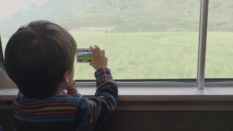 4-Year-Old Boy Taking Photos on Train Journey Through Rural South China 스톡 동영상 329635016