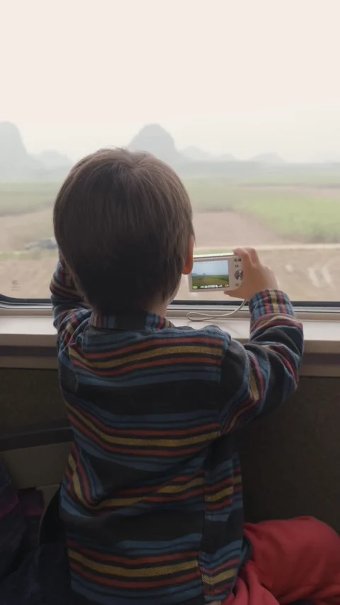 4-Year-Old Boy Taking Photos on Train Journey Through Rural South China Stock Footage 329635107