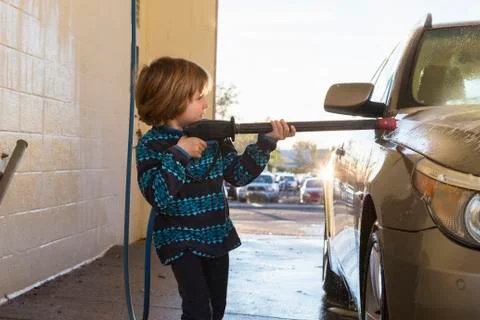 4 year old boy washing a car in car wash Stock Photos