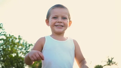 4-year-old boy in a white t-shirt laughs and stretches out his hands. Portrait Stock Footage 94130411