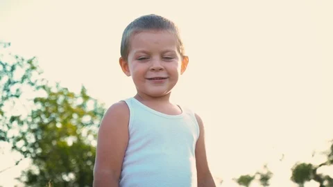 4-year-old boy in a white t-shirt laughs, kid jumps up and shows the class on Stock Footage 94130430