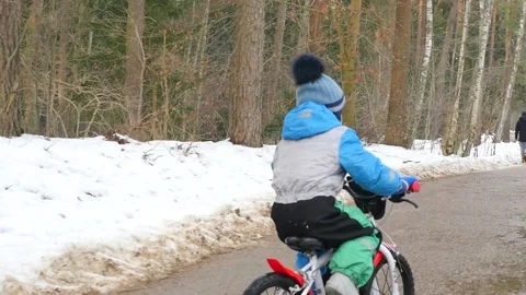 4 years old boy on bicycle driving in park back view slow motion Stock Footage 149552425