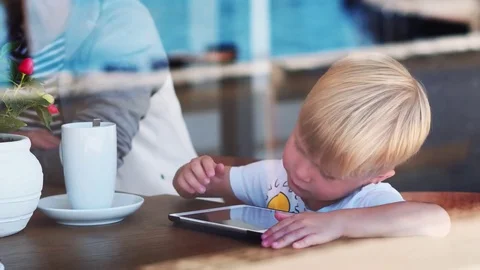 4 years old children boy sitting at the wooden desk while playing with the Stock Footage 82201127