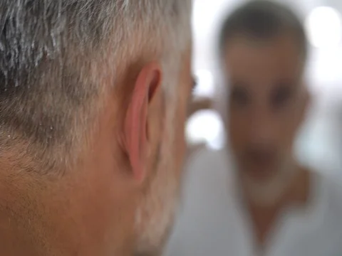 40-year-old man checking hair in front of mirror Stock Footage 81728025