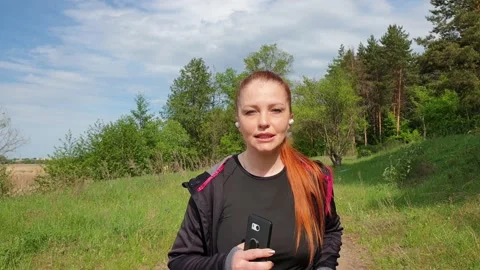A 40-year-old vivacious beautiful woman with bright red hair in the park is Vídeo Stock 154542930