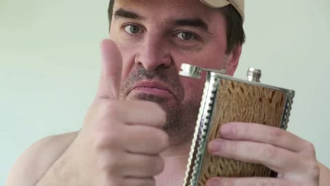 40 years old drunk man drinking alkogol from a metal flask, like it Stock Footage 130564569