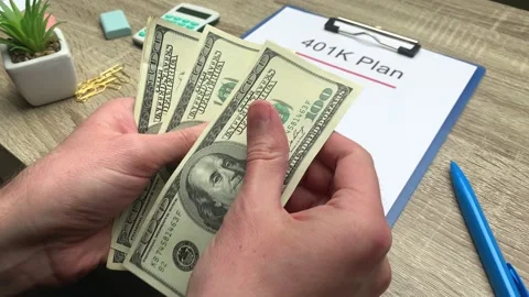 401k retirement plan, a man counts 100 dollar bills at a wooden table Stock Footage 130357166