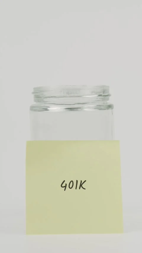 401k text or word on yellow sticky note attached to glass jar with hand Stock Footage 311675034