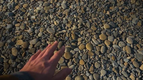 419. A man's hand takes a smooth sea stone and throws it into the sea. Stock Footage 104153148