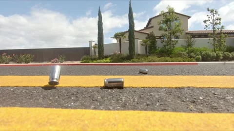 .45 caliber bullet casings falling into the street in slow motion. Stockbeeldmateriaal 162077922