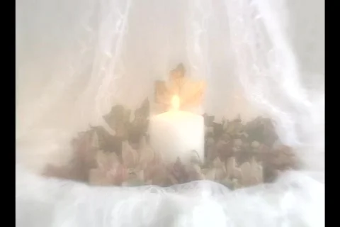 4504 Single lite candle on white silk and flowers Stock Footage 795200