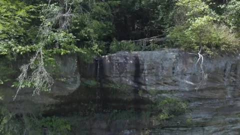 454 Aerial of a small waterfall going into a canyon Видео 133258916