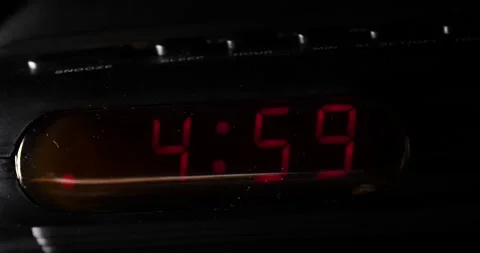 4:59 a.m. to 5:00 a.m. clock change close-up on black digital clock Stock Footage 204059848