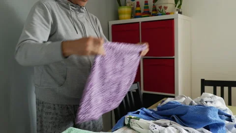 A 47 year old single or divorced man folding clothes at home Stock Footage 182410716