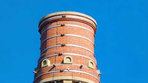 48616 Tower With Brick Structure Against Clear Blue Sky Showcasing Architec.. Stock Footage 304168664