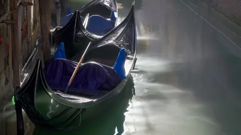 48664 Gondolas Resting in a Quiet Canal at Dawn in Venice Showcasing the Se.. Stock Footage 304169466