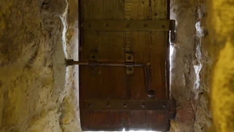 48689 Unique Wooden Door With Rustic Hardware in a Stone Wall Offers Glimps.. Stock Footage 304169869