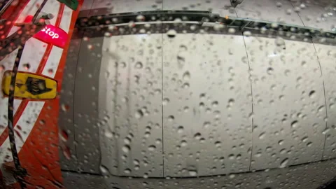 48700 Rain Droplets Collect on a Window While a Car Waits at a Red Stop Lig.. Stock Footage 304169951